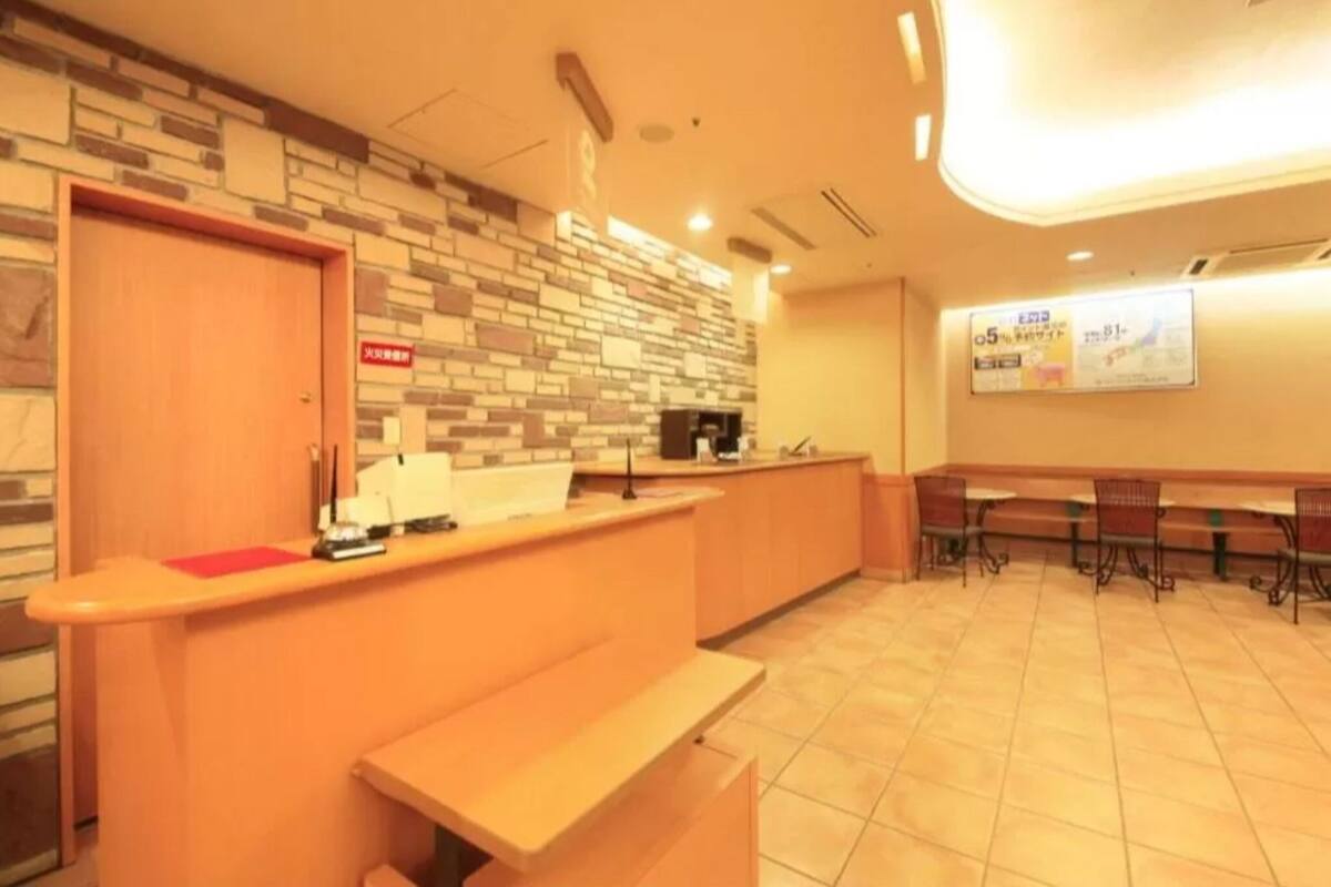 A reception area with a counter, a bench, and a wall with a patterned design.