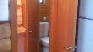 A wooden interior with a visible door leading to a bathroom, a white refrigerator, and a wooden floor. - Tm Resrot Kijimadaira (Kijimadaira)