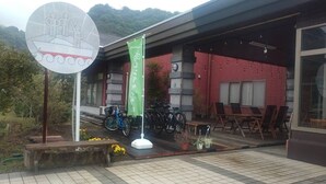 Un edificio de ladrillo rojo, con una zona de estar al aire libre cubierta y bicicletas estacionadas fuera.
