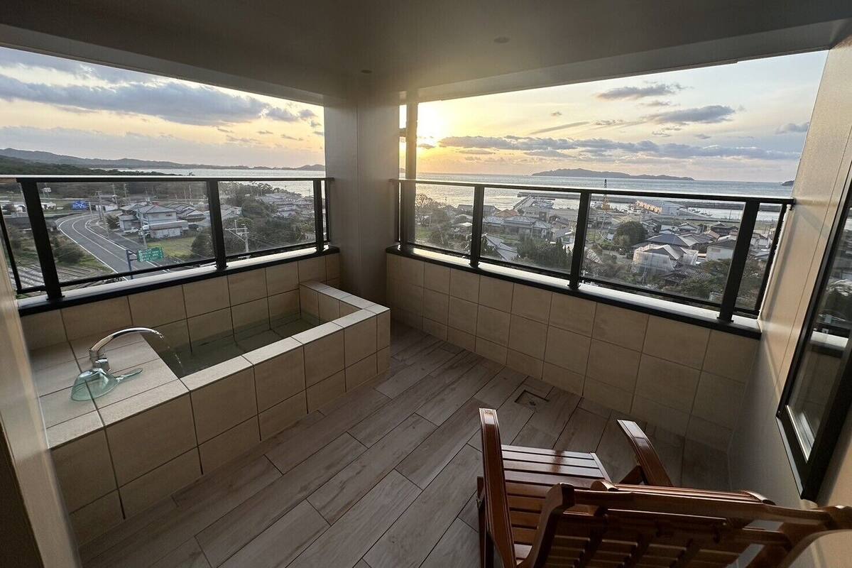 Ein Balkon mit Blick auf eine Stadtansicht und einer Badewanne.
