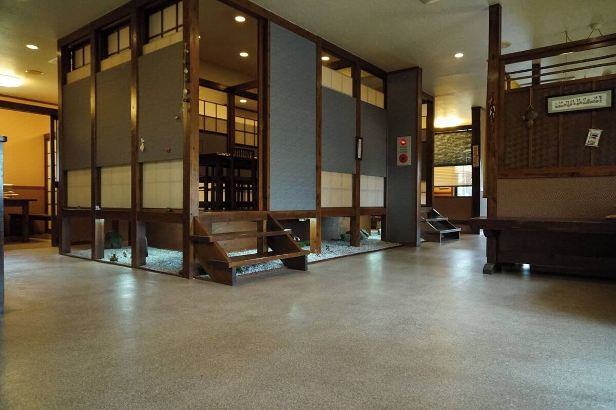 Ein traditioneller japanischer Raum mit Schiebetüren, Tatami-Böden und einem niedrigen Holztisch.