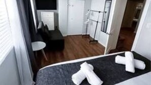 A hotel room with a bed, a small seating area, a door, and a window with curtains. - Ocean Breeze Bungalow 4BR 2BA W Pool (Hollywood)