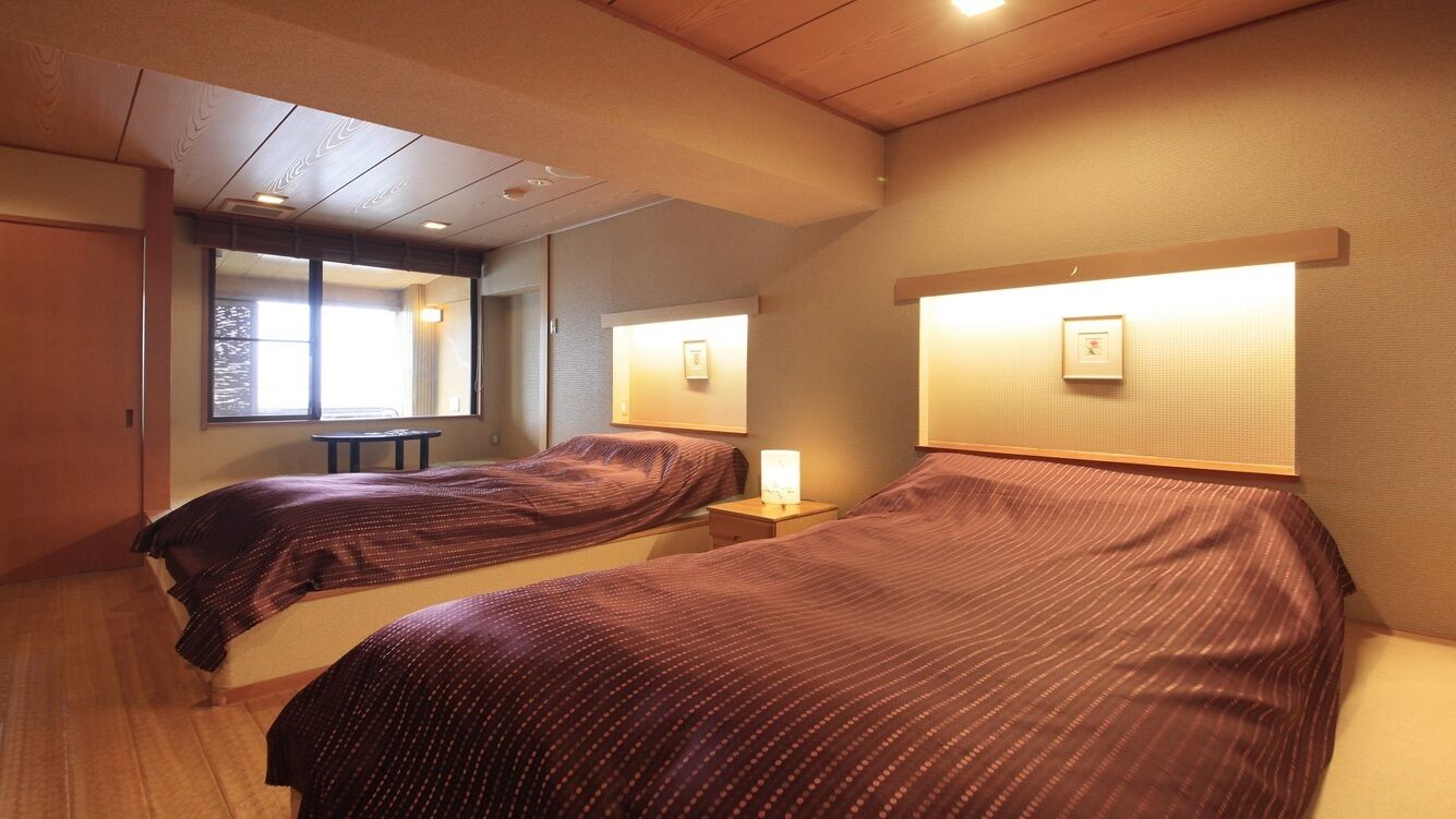 Ein Hotelzimmer mit zwei Betten, einem kleinen Tisch und einem Spiegel.