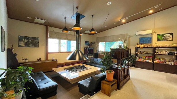 A cozy living room with a fireplace, comfortable seating, and a small kitchen area.