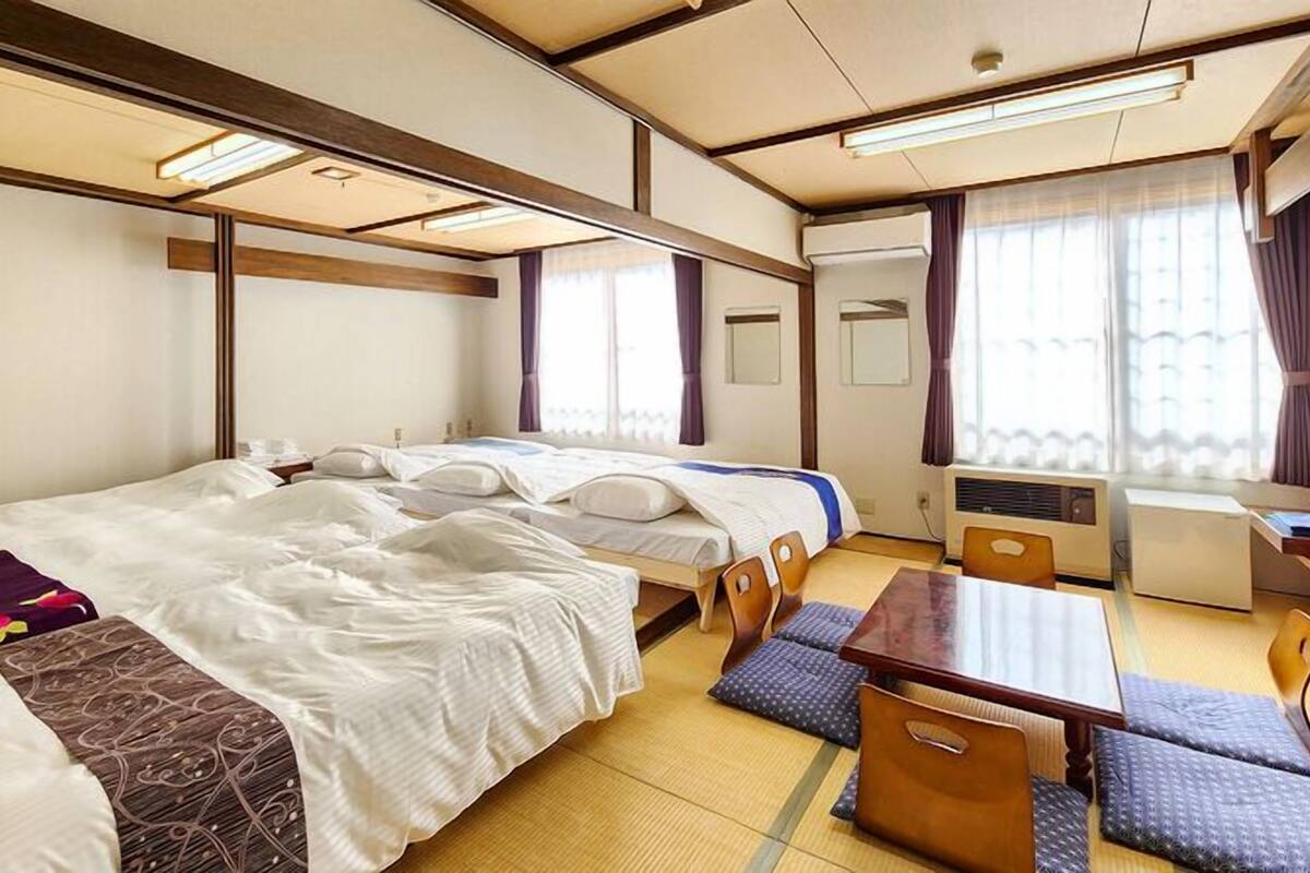 Une chambre d’hôtel avec deux lits, une table à manger et un coin salon.
