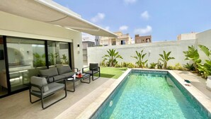 Uma área moderna de piscina ao ar livre, com espaço para sentar e piscina azul cristalina.