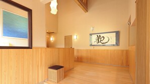 A wooden interior with a reception desk, a framed artwork, and a wooden bench.
