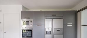 Eine moderne Küche mit integrierten Geräten, darunter eine Mikrowelle, ein Backofen und ein Kühlschrank.