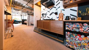 An office space with a kitchenette, a wall-mounted TV, and a wall of stickers. - Illi Nakano (Tokyo)