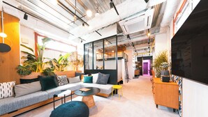 A modern interior with a sofa, round coffee table, and potted plants. - Illi Nakano (Tokyo)