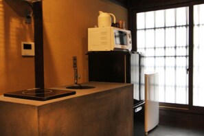 Ein Zimmer mit integrierter Küchenzeile, einer Mikrowelle und einer Kaffeemaschine.
