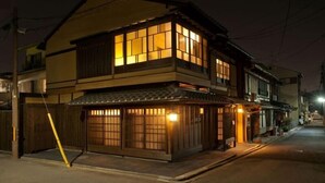 A traditional Japanese house with a two-story structure, a tiled roof, and a wooden facade. - Kyoto Ryoan Zen (Kyoto)