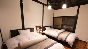 A room with two beds, wooden flooring, and a window with a view. - Kyoto Ryoan Zen (Kyoto)