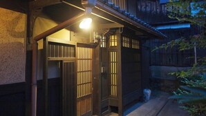A traditional Japanese building with wooden doors and a small porch area. - Demizu Machiya (Kyoto)