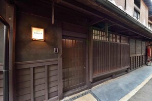 A traditional Japanese building with a wooden facade, a sliding door, and a sign indicating the name 'Takaya.' - Takeya Kitano Honkan (Kyoto)