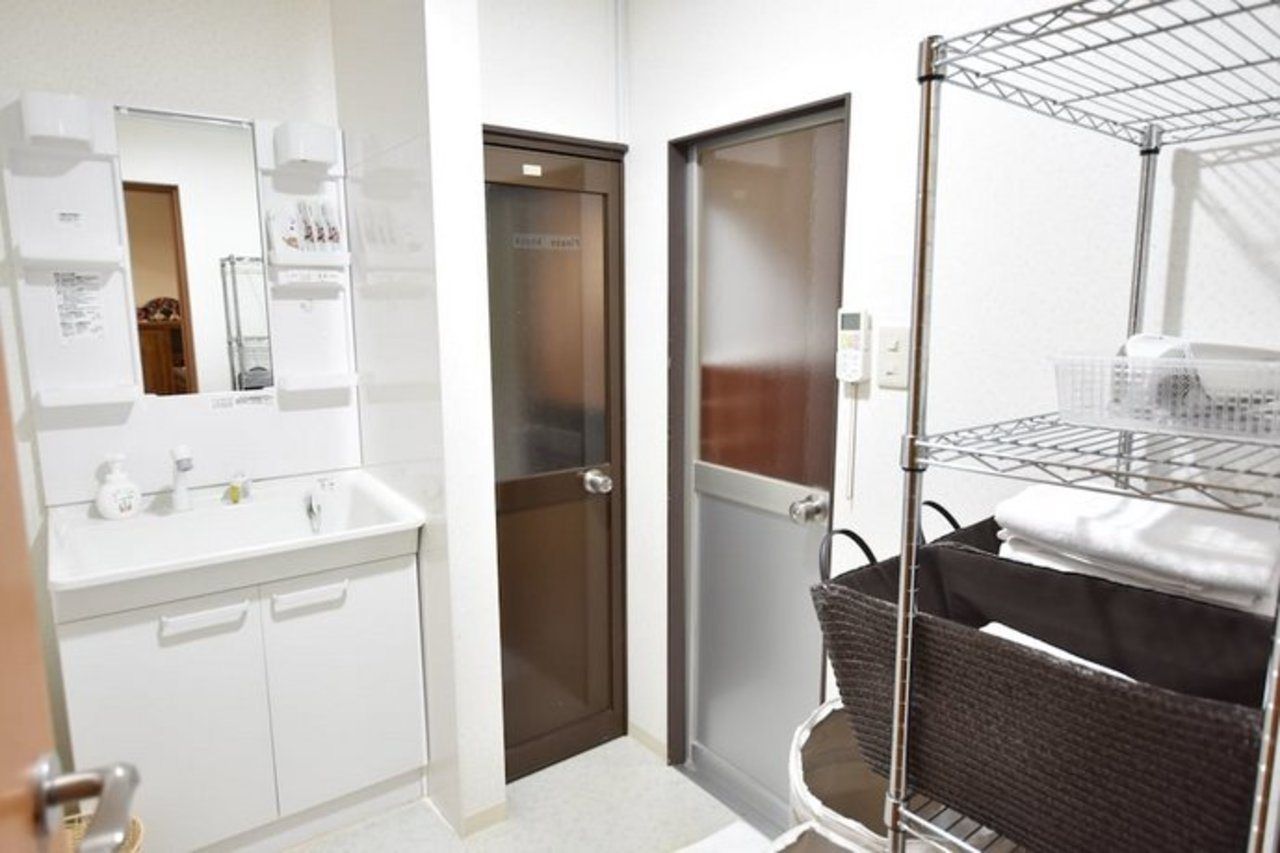 A bathroom with a white sink, mirror, and a towel rack.