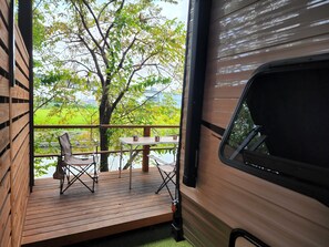 An RV with a wooden deck and outdoor seating area. - Kyushu RV Resort in Yanagawa (Yanagawa)