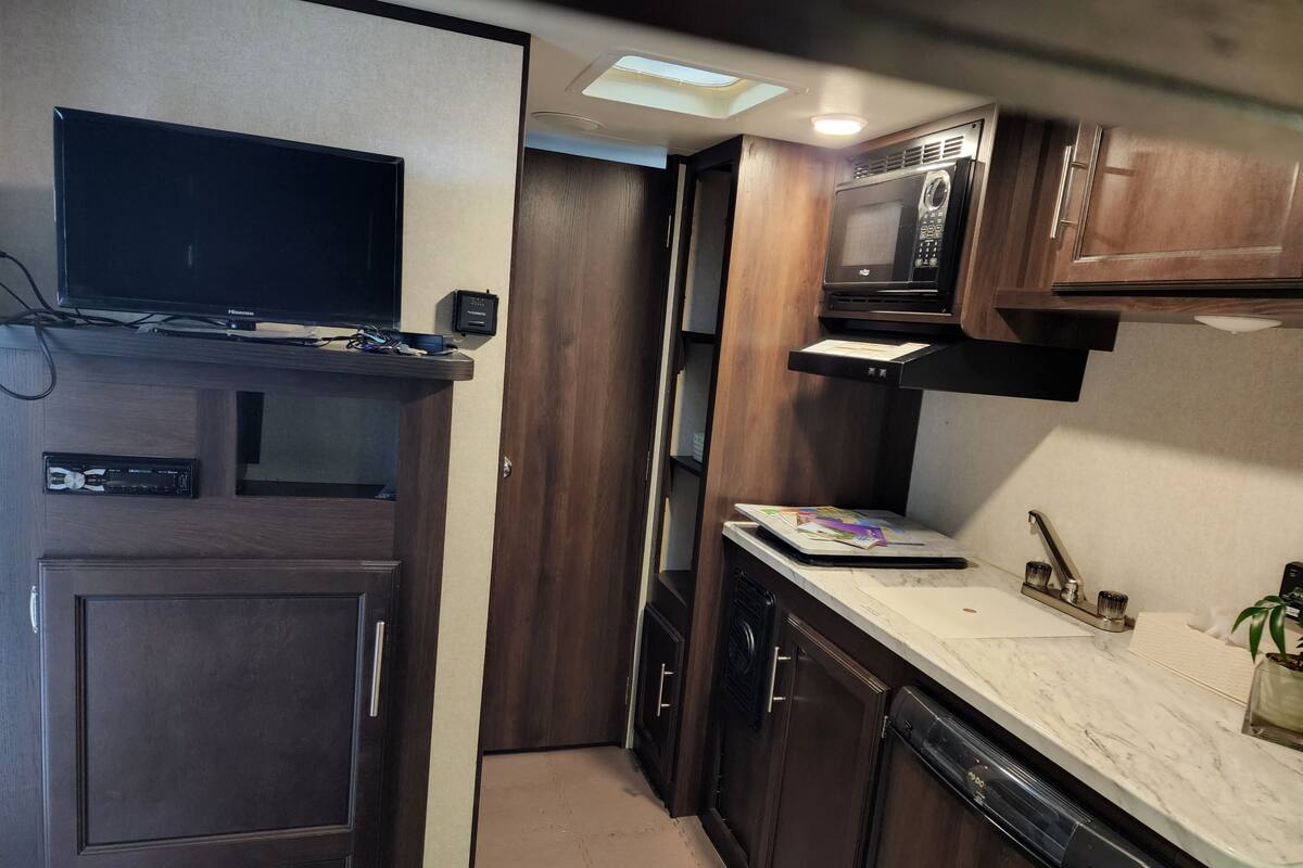 A compact kitchen with a microwave, a coffee maker, and a small refrigerator.