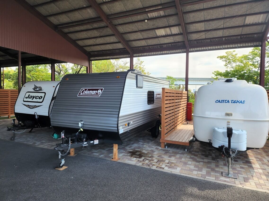 A covered parking area with a Coleman RV and a Jayco camper.