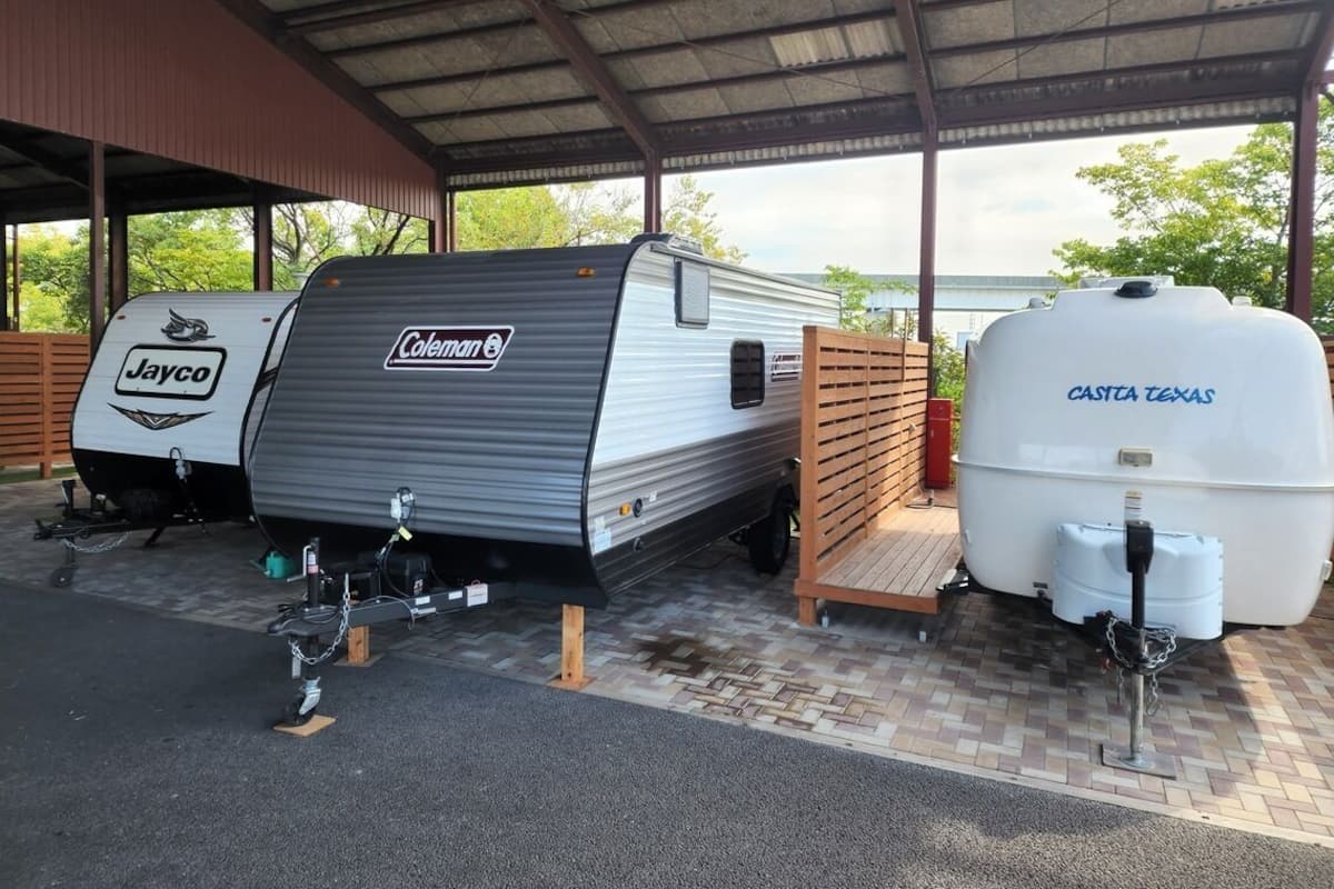 A covered parking area with a Coleman RV and a Jayco camper.