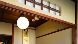 Ett traditionellt japanskt rum med tatamimattor på golvet, ett lågt träbord och en skjutdörr.