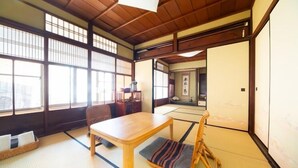 Ett traditionellt japanskt rum med tatamimattor på golvet, ett lågt träbord och en skjutdörr.