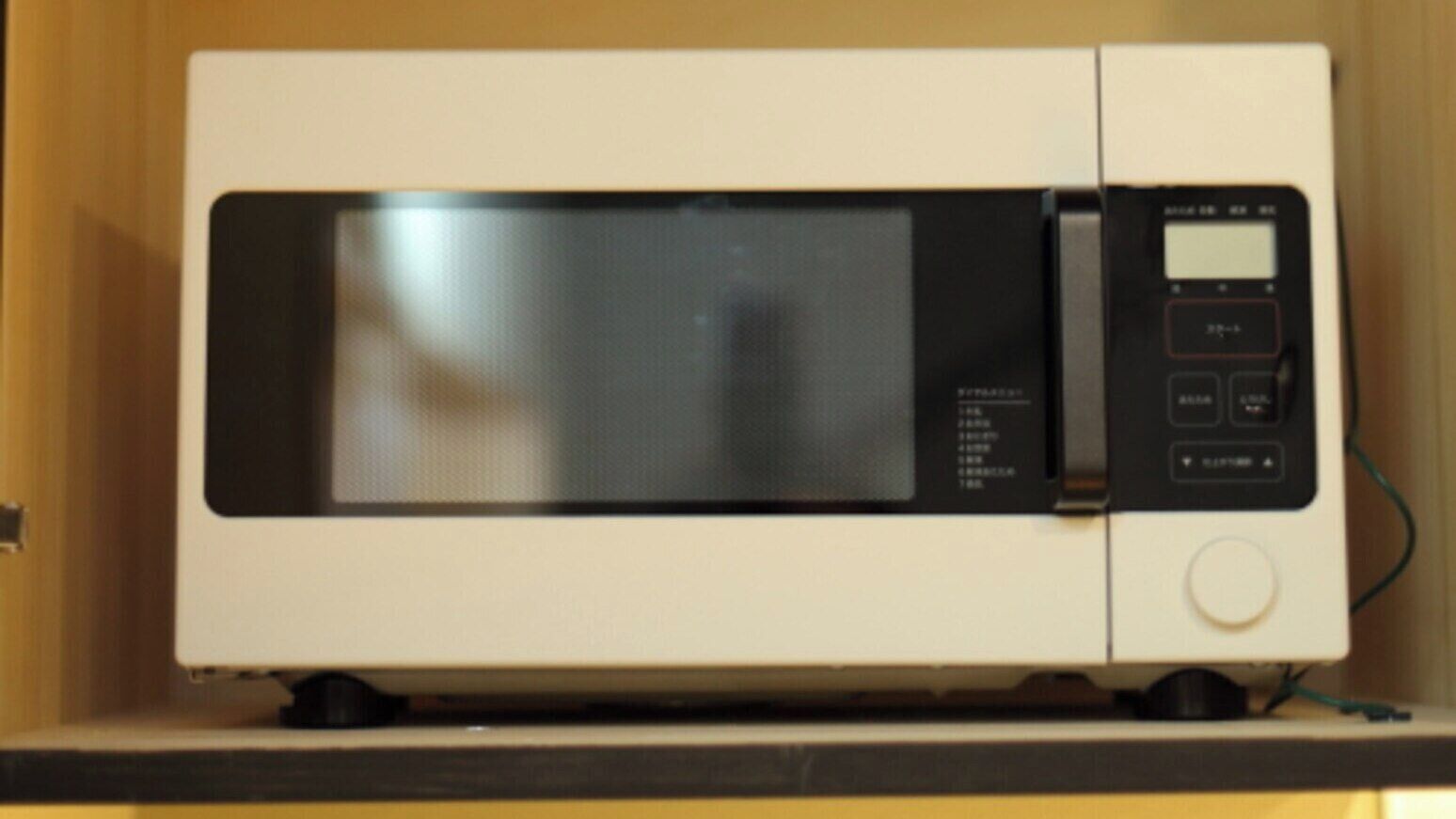 A microwave oven with a digital display and control buttons.