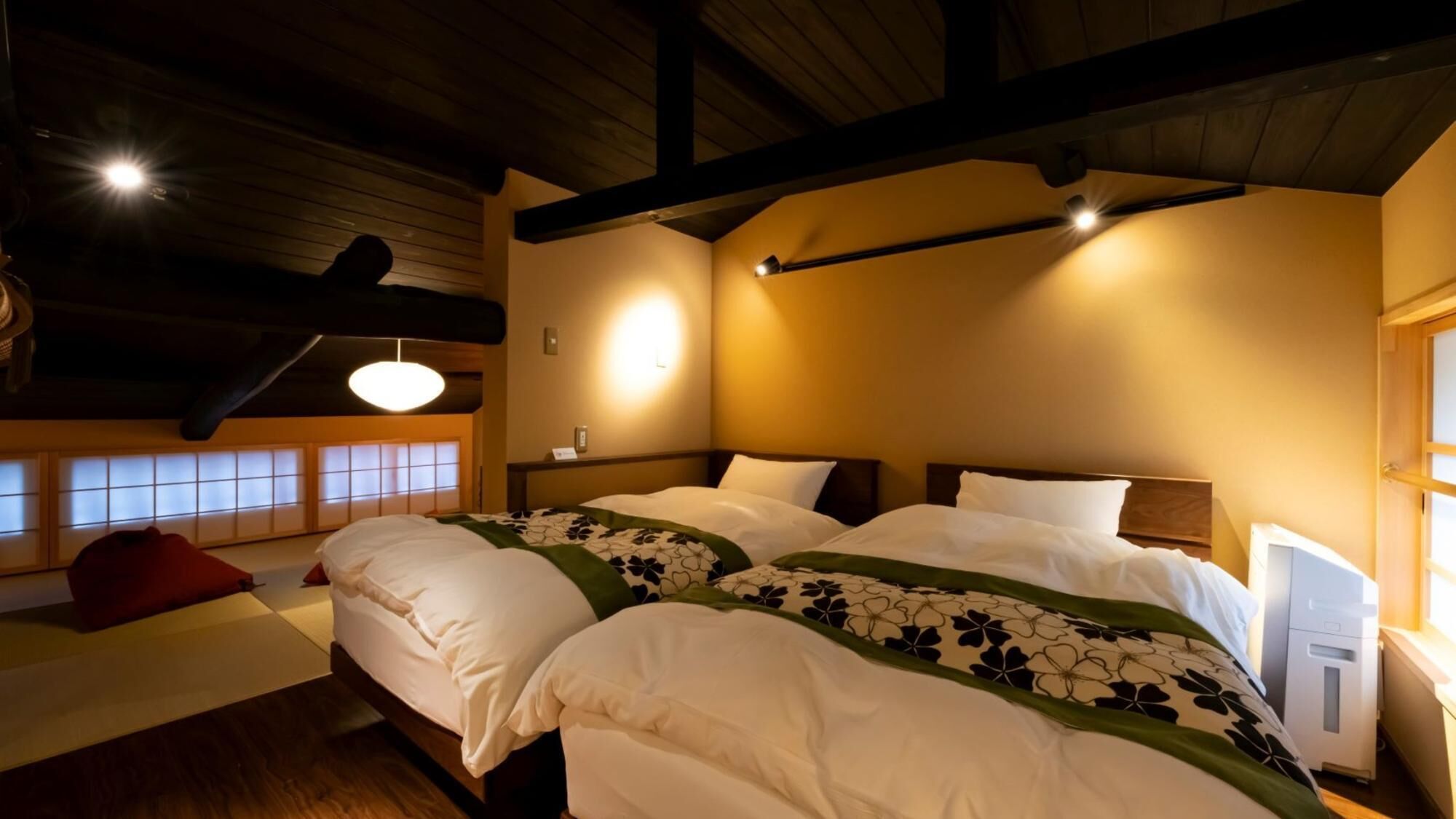Ein Hotelzimmer mit einem großen Bett, einem Schreibtisch, einem Stuhl und einem Fenster mit Blick.