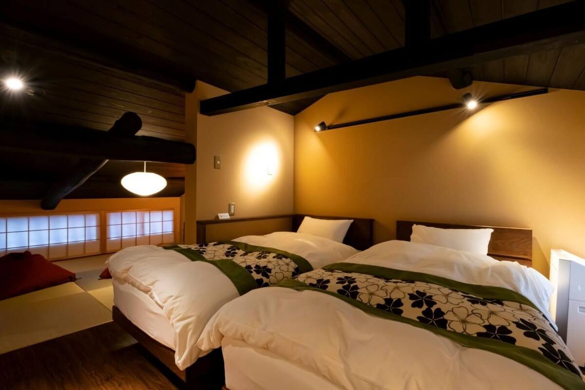 A hotel room with a large bed, a desk, a chair, and a window with a view.