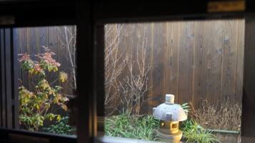 A wooden fence, a stone lantern, and some plants.