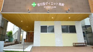A building with a sign reading 'EMBELLIR' and a green cross symbol. - Embellir (Ibaraki)