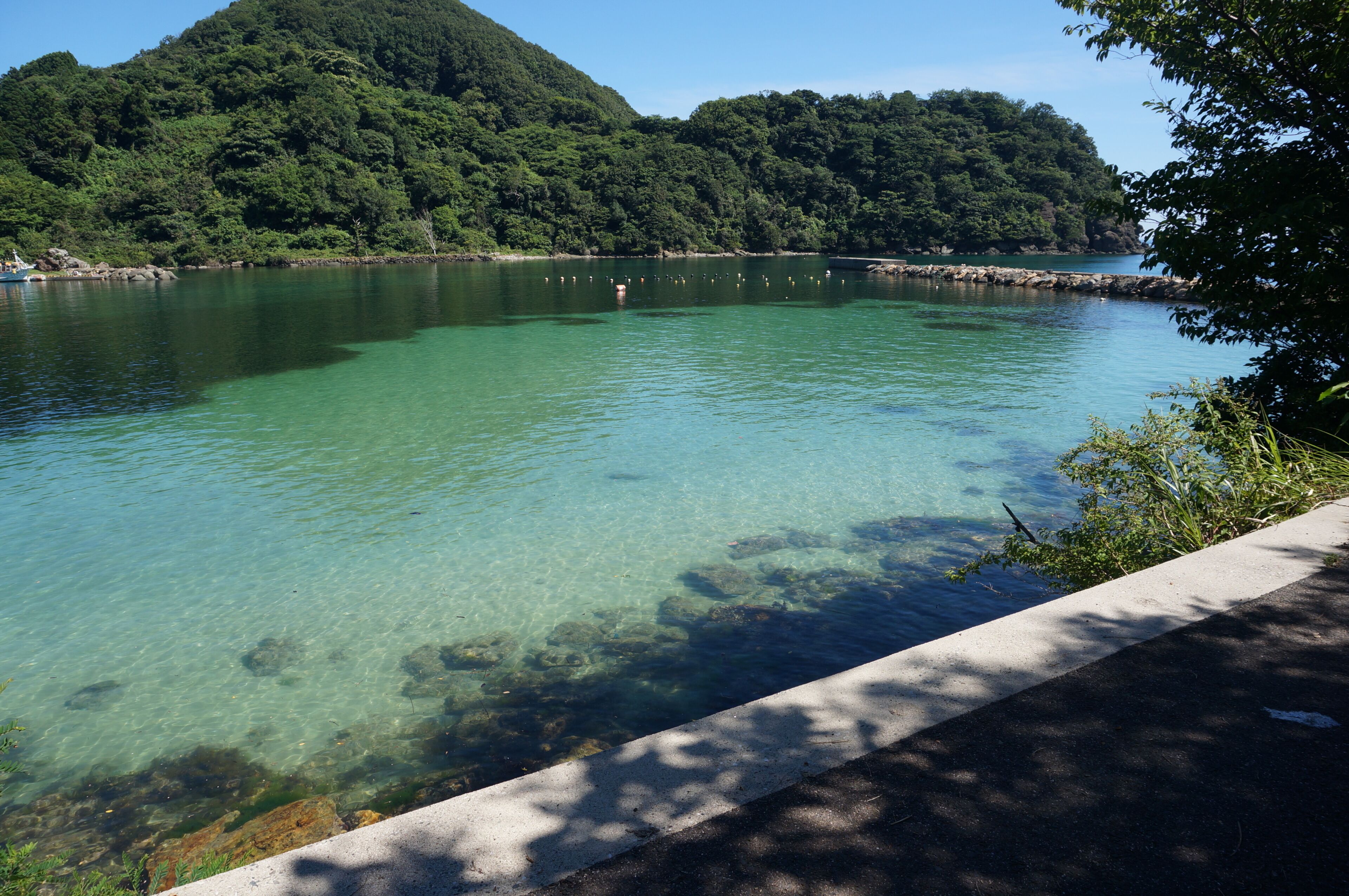 Un lac aux eaux limpides, bordé d’une promenade en béton.
