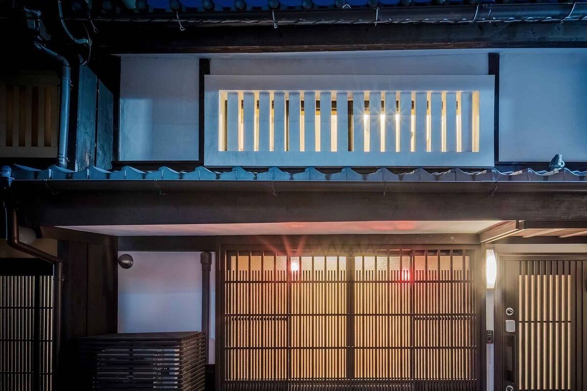 A traditional Japanese building with a wooden gate, a small shrine, and a tiled roof.
