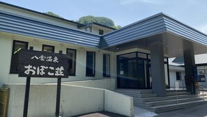 A building with a signboard, a covered entrance, and a staircase leading up to the entrance. - Obokoso (Yakumo)