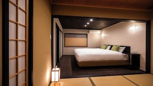 Quarto com cama, mesas de cabeceira, ar condicionado fixado na parede e porta deslizante.