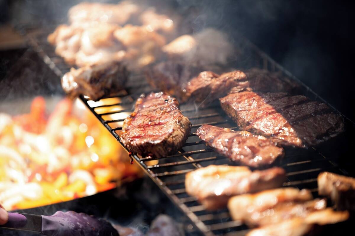 A grill with various meats being cooked.