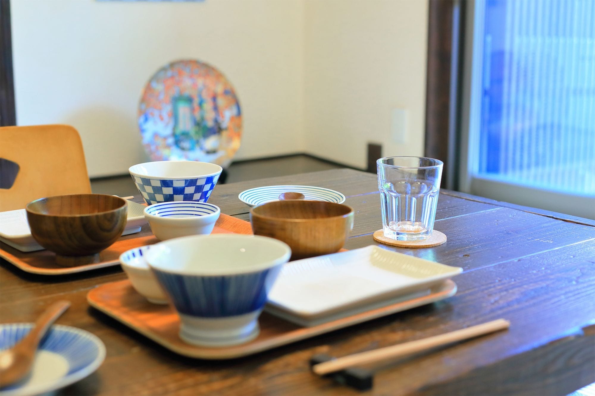 A dining table with various bowls, chopsticks, and a glass of water.