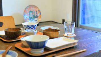 A dining table with various bowls, chopsticks, and a glass of water.