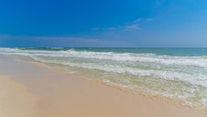 Una spiaggia con cielo sereno e onde.