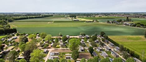 A residential area with multiple houses and a large green field.