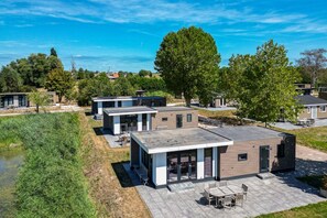 Un complejo residencial moderno con varias casas, un patio central y una masa de agua.