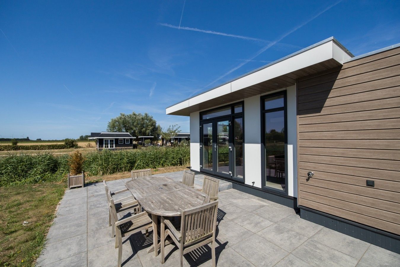 Una casa moderna con un patio, una mesa de comedor y sillas.