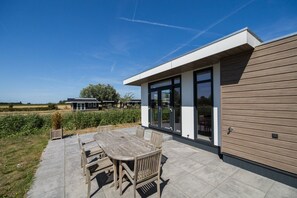 Una casa moderna con un patio, una mesa de comedor y sillas.