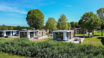 Un quartier résidentiel moderne composé de plusieurs maisons, chacune dotée d’une terrasse aménagée avec du mobilier d’extérieur.