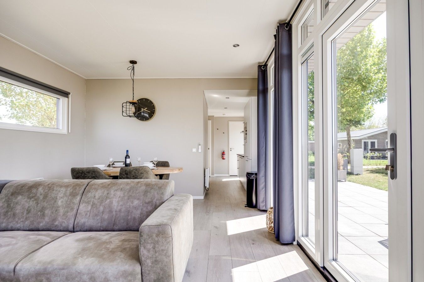 Un salon moderne avec un canapé, une table à manger et une grande fenêtre.