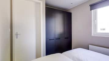 A bedroom with a bed, a wardrobe, and a window.