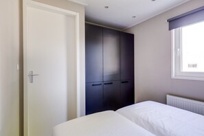Ein Schlafzimmer mit einem Bett, einem Kleiderschrank und einem Fenster.
