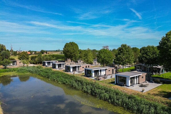A modern residential area with multiple houses, a body of water, and a clear sky.