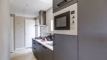 A modern kitchen with a built-in microwave, a stove, and a sink.