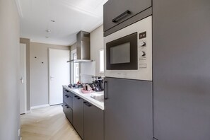 Una cocina moderna con microondas integrado, estufa y lavaplatos.